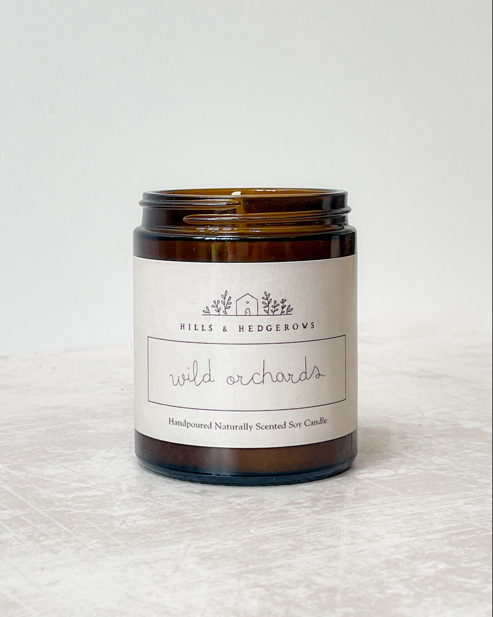 Wild Orchards natural soy wax candle, hand-poured sustainable luxury, perfect for relaxation and rejuvenation. In amber class jar with neutral label comes in cotton drawstring gift pouch.