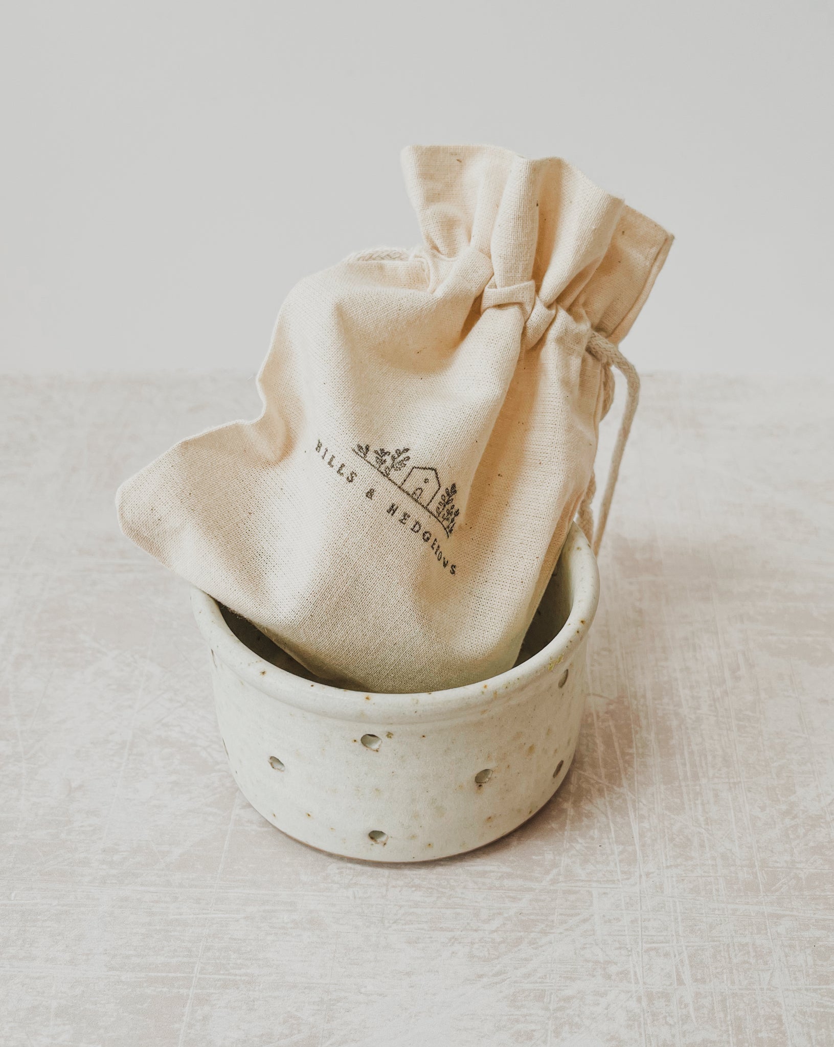 Handthrown Ceramic Candle Holder with Beeswax Tealight Gift Set from the Derbyshire Peak District, featuring a speckled clay design with polkadot punctures and raw off-white matte glaze.