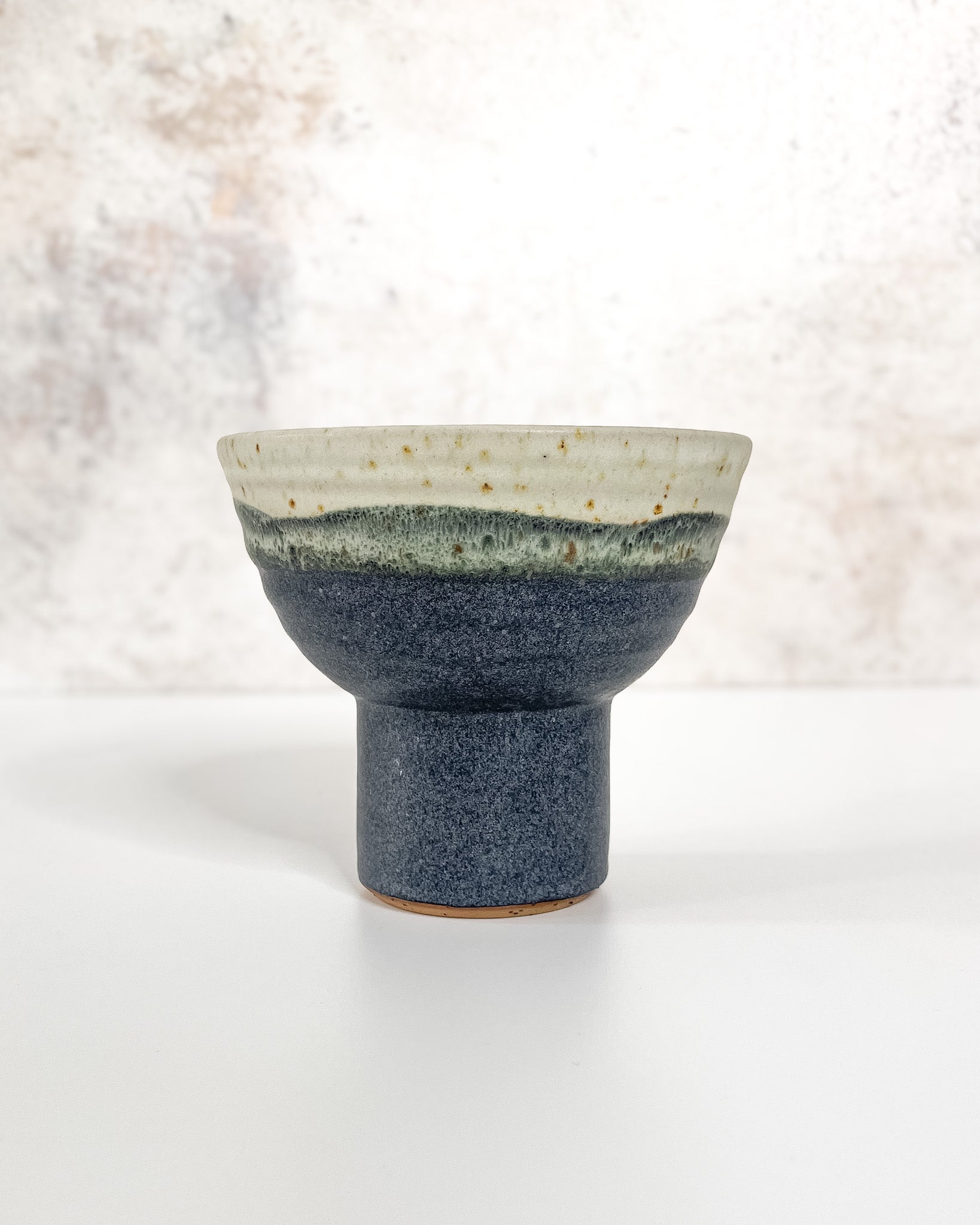 Hand-thrown ceramic Ikebana vase set in midnight blue glaze, featuring an elevated base and stem holder for floral displays.