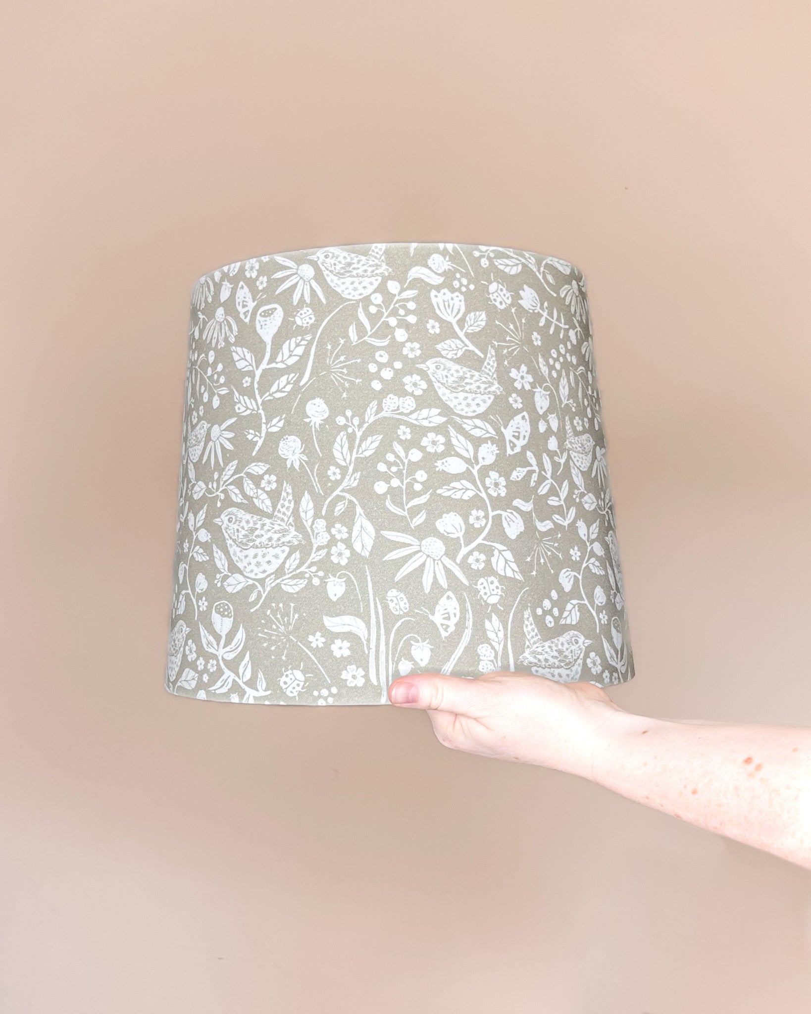 Handmade Wren’s Hedgerow botanical lampshade with a Jenny Wren, flora, and fauna design on warm stone fabric.