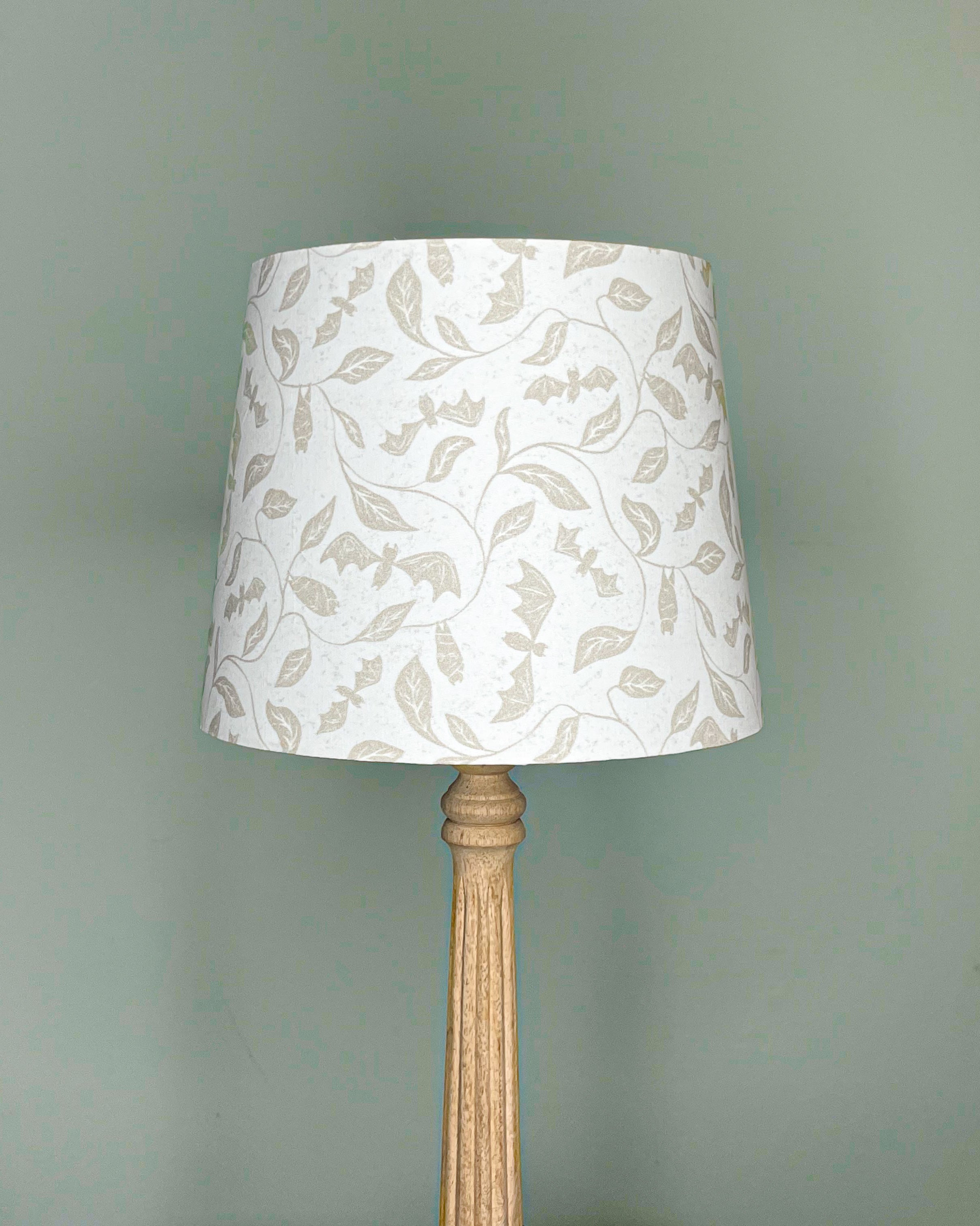 Entwined Bats Halloween Lampshade with whimsical bats and botanical leaves in soft beige tones, handmade with cotton poplin, perfect for UK home decor.