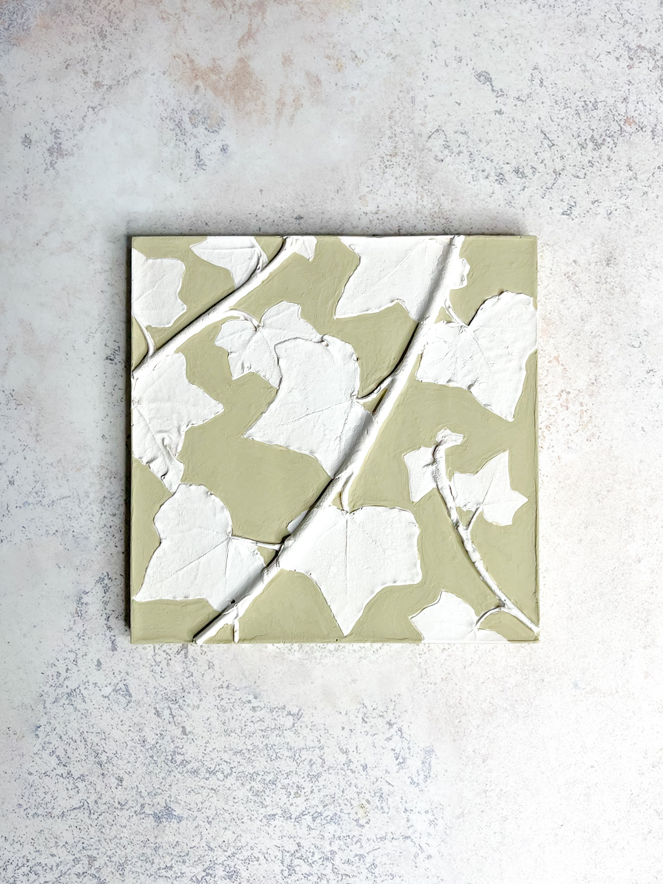 Handcrafted botanical relief tile with ivy imprint, hand-painted in soft olive green, symbolising friendship and resilience.