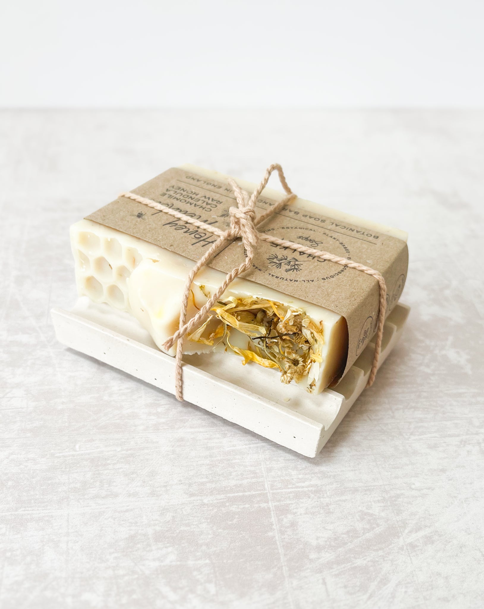 Natural essential oil botanical honey soap bar on neutral soap dish made in the UK