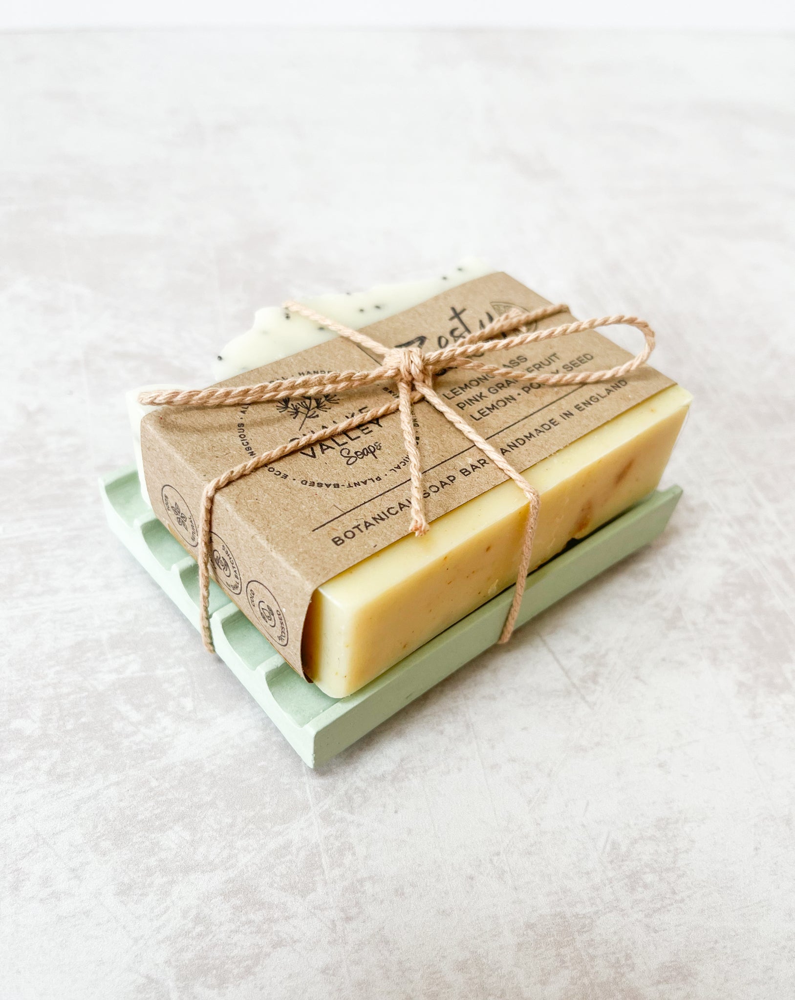 Natural essential oil botanical zesty soap bar on green soap dish made in the UK