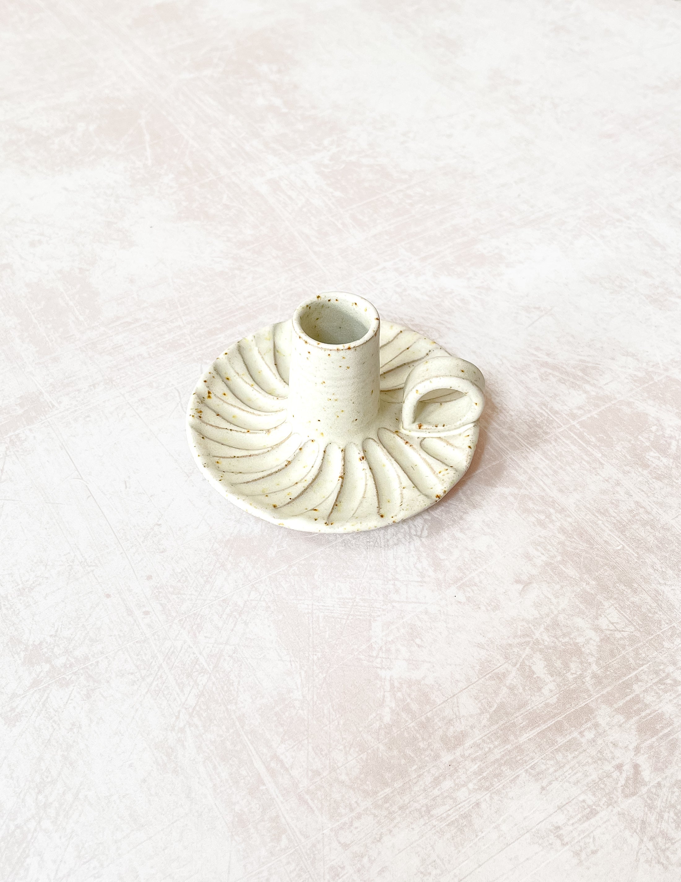 Handcrafted Ceramic Candle Holder with Decorative Beeswax Candles, featuring a speckled clay design with an off-white matte glaze, fluted finish, and looped handle, adorned with dried flowers.