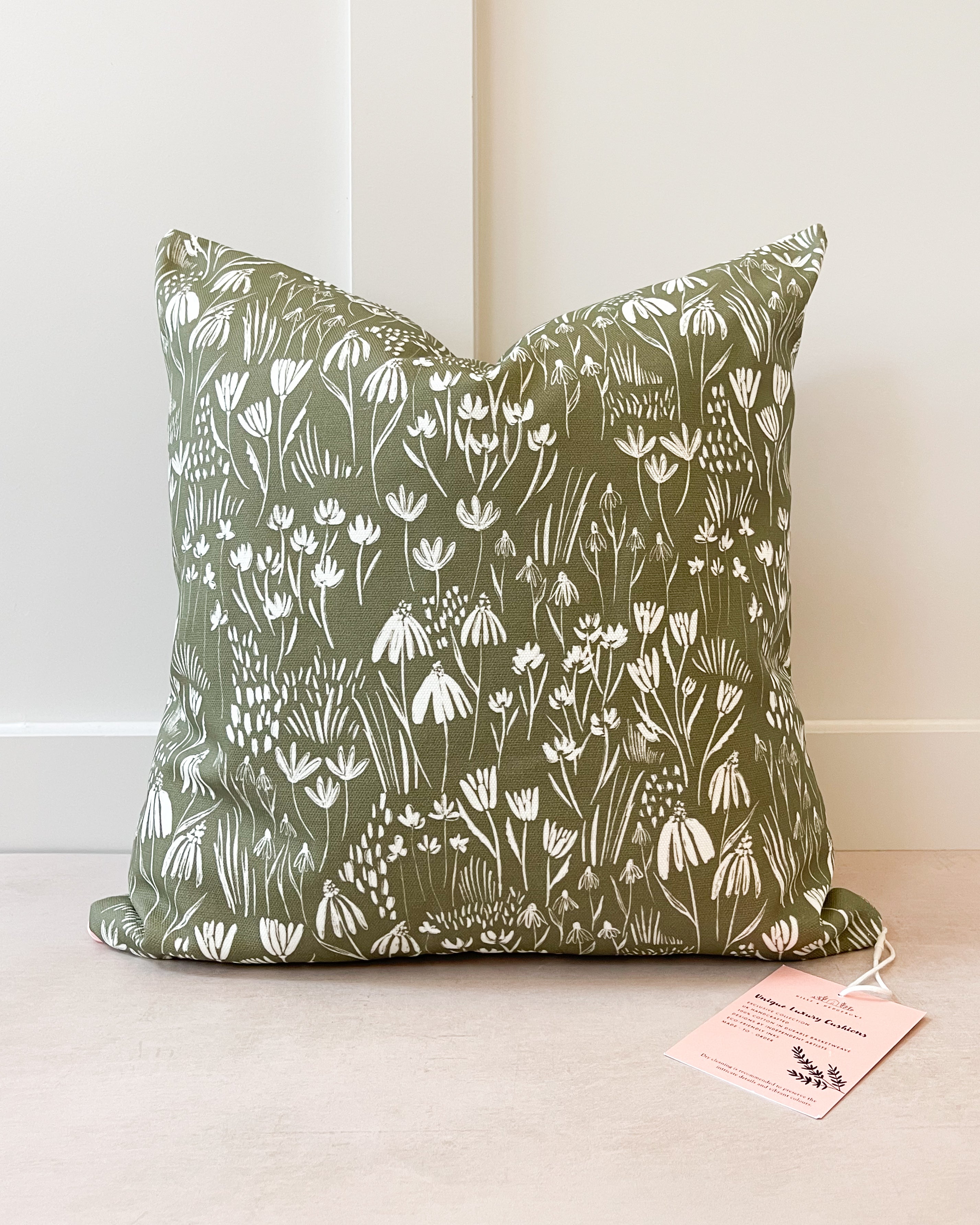 Botanical-inspired decorative cushion with lush green and floral patterns, handmade in the UK from sustainable basketweave cotton.