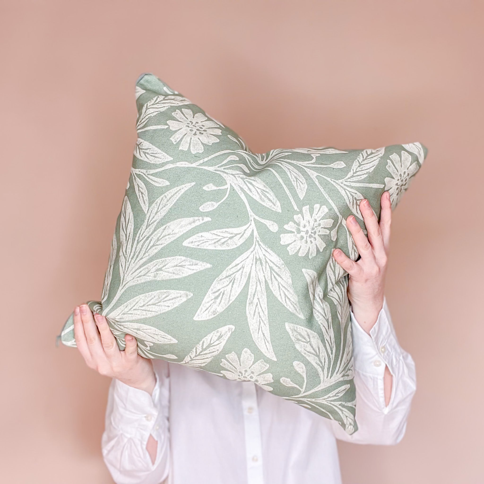 Meet Hills & Hedgerows Creator and Designer_Hiding face behind bold floral scatter cushion