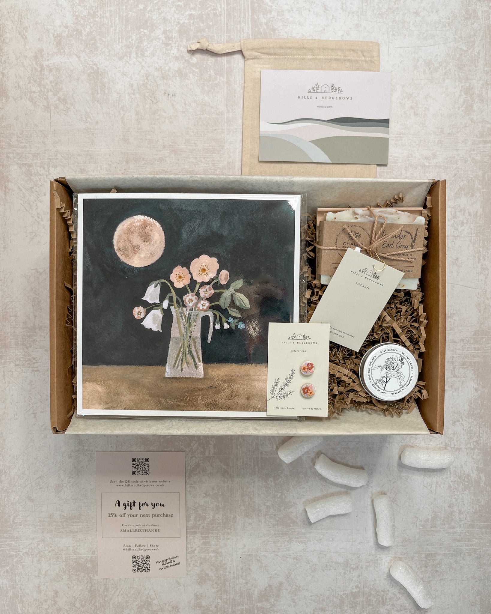 Beautifully curated Midsummer Moon & Blooms Gift Set featuring a Midsummer Moon print, polymer clay stud earrings with little flowers in shades of pink, rose garden tealight, and lavender earl grey soap bar on a concrete soap dish, perfect for celebrating nature’s beauty.