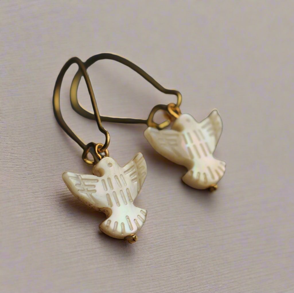 Handcrafted Mother of Pearl Dove Earrings with gold-plated ear wires. Delicate design with a soft, glowing sheen, made in the UK. Ideal for autumn and winter, gift-ready in a cotton pouch.