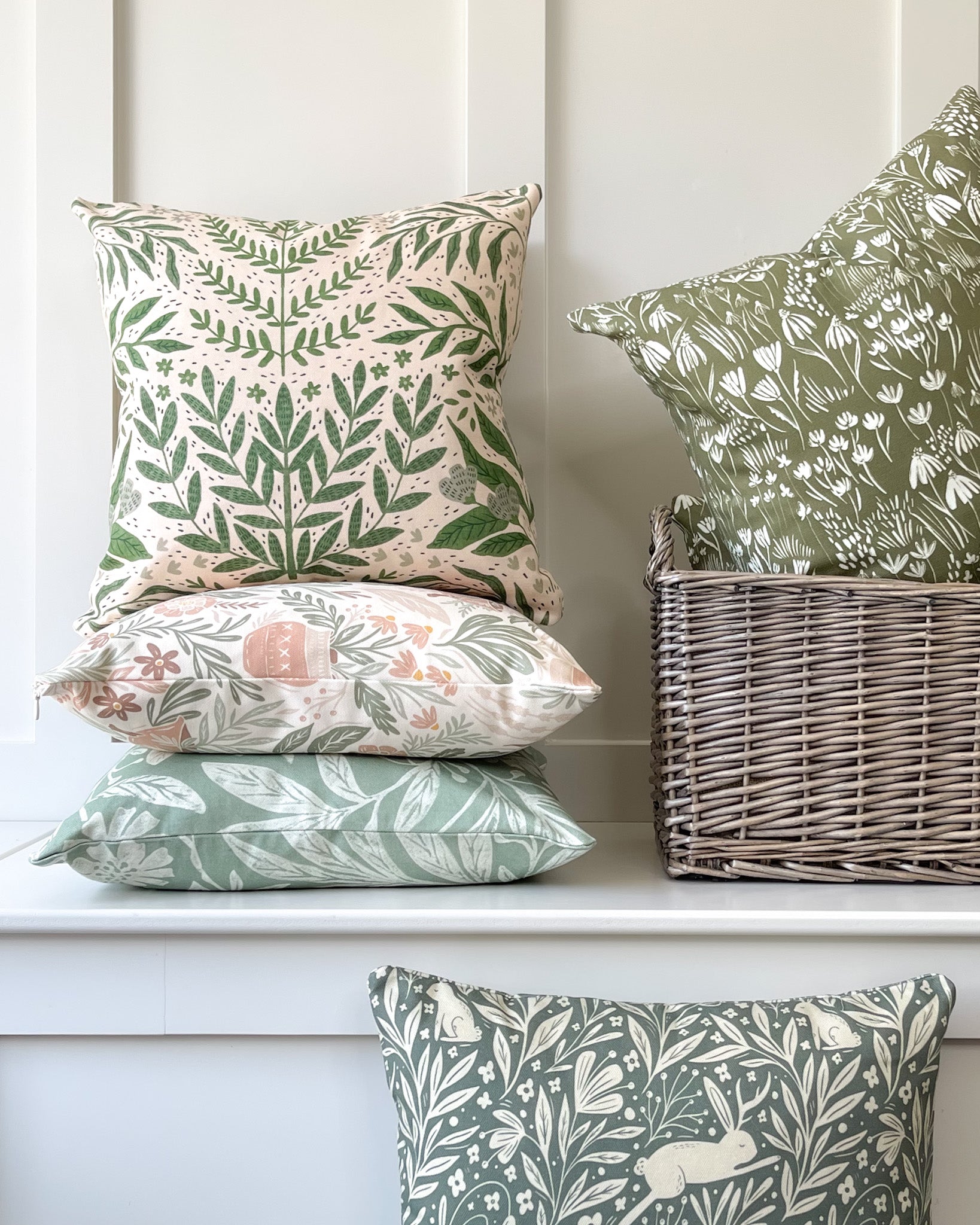 Wildflower Meadow Cushion featuring a warm deep green background with a cream wildflower pattern, made of basketweave cotton with a duck feather insert, designed by independent artists.