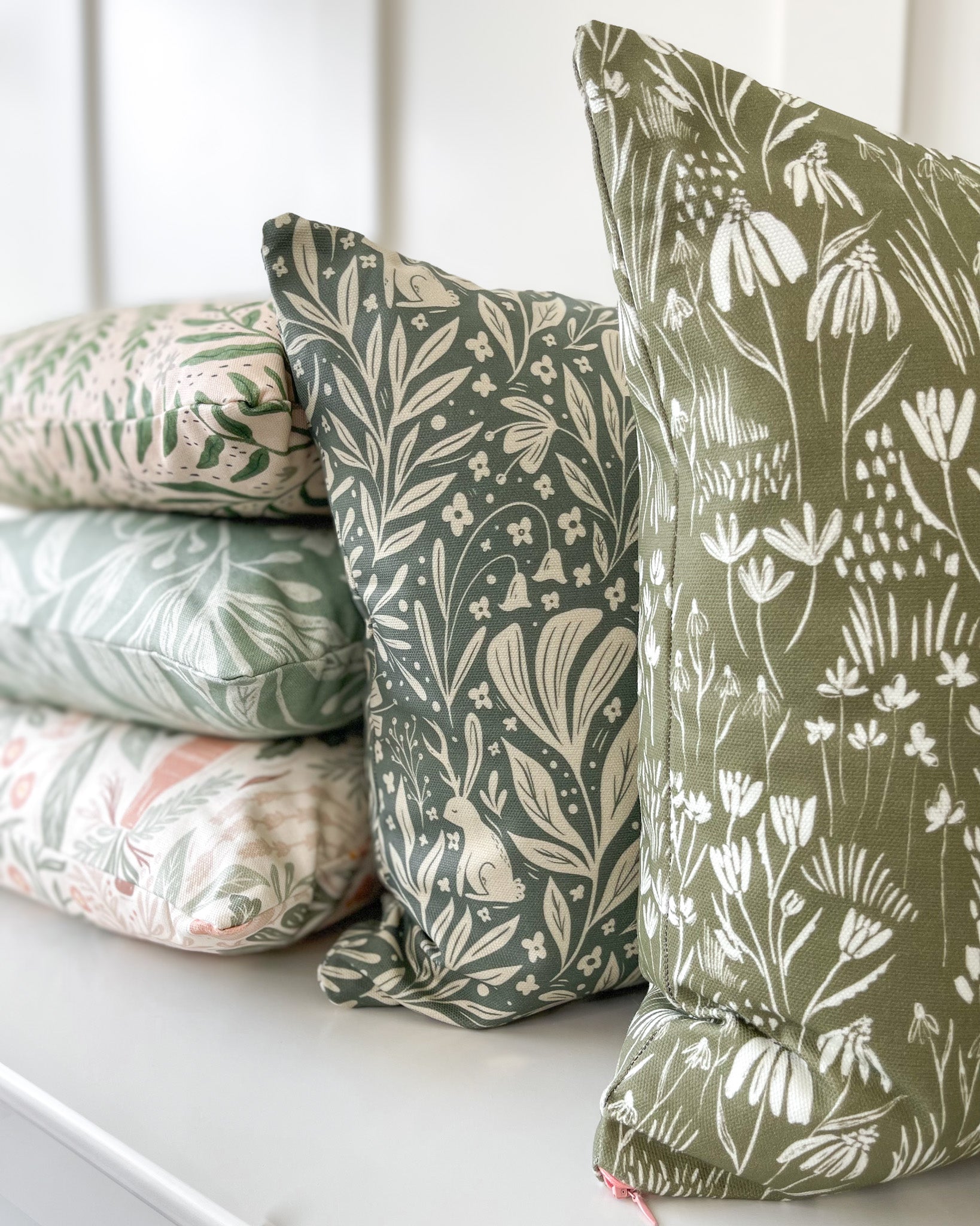 Wildflower Meadow Cushion featuring a warm deep green background with a cream wildflower pattern, made of basketweave cotton with a duck feather insert, designed by independent artists.
