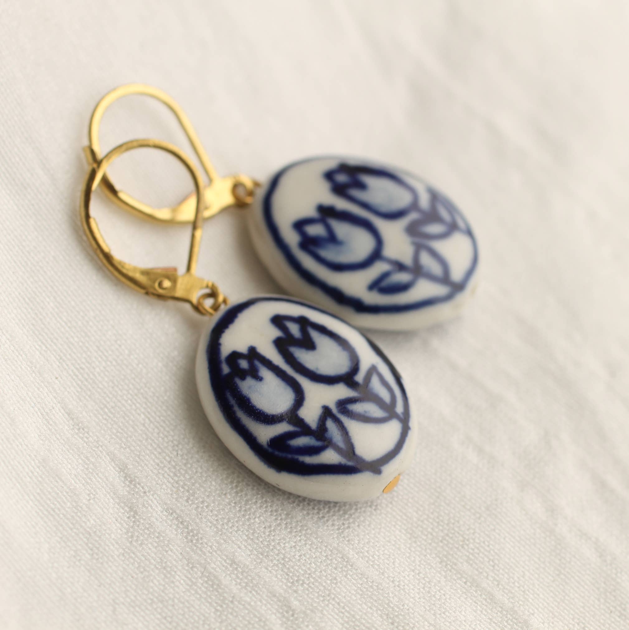 Handcrafted Oval Blue Tulip Earrings, porcelain with brass earwires. Nature-inspired design, perfect for autumn and winter, gift-ready in a cotton pouch.